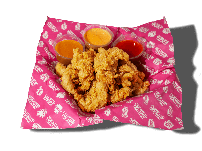 A basket of hand-crafted Asian chicken tenders with three signature dipping sauces, a popular meal in South Beach, Miami