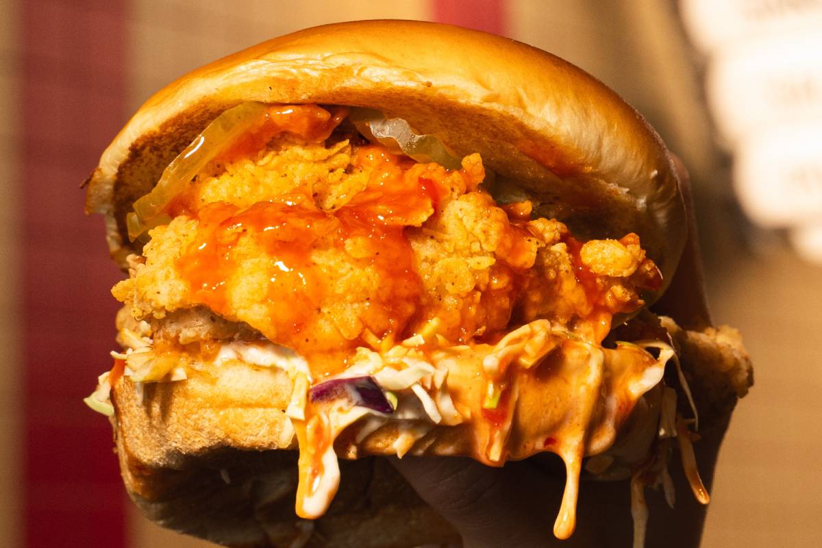 Close-up of a classic crispy chicken sandwich held in a customer's hand at our restaurant in Miami.